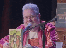 a man is holding a comic book in front of a microphone with a sign that says chicago talk