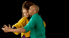 a man and a woman are dancing together and the woman is wearing a yellow sweater