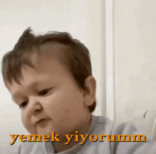a baby making a funny face with the words yemek yiyorum in the upper right corner