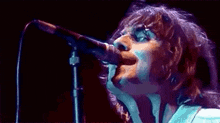 a close up of a person singing into a microphone on a stage .