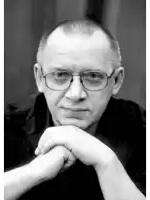 a man with glasses rests his head on his hands