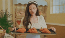 a woman is holding a tray of pastries in her hands .