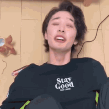 a young man wearing a black shirt that says stay good