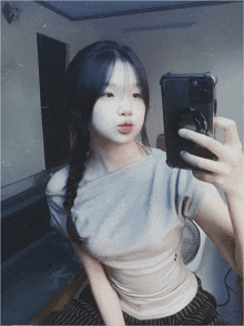 a girl taking a picture of herself in a mirror with her phone