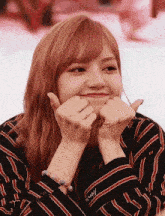 a woman is making a heart shape with her hands .