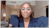 a woman is wearing glasses and a blue jacket
