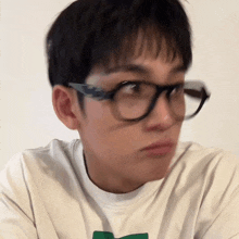 a young man wearing glasses and a white shirt