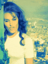 a woman with blue hair and a white shirt is standing in front of a city
