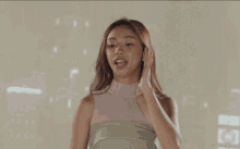 a woman in a pink top is smiling and looking to the side