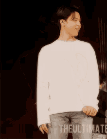 a man in a white sweater is dancing on a stage with the ultimate written on the bottom right
