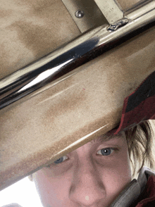 a close up of a person 's face underneath a metal railing