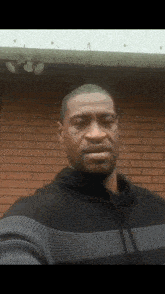a man taking a selfie in front of a red brick wall