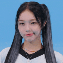 a girl with pigtails is wearing a necklace with a rabbit on it