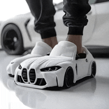 a person wearing a pair of slippers that look like a car