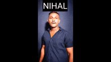 a man in a blue shirt is standing in front of a black background with the word nihal on it