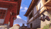a building with a mountain in the background and a cannon in front of it