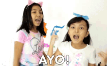 two young girls are standing next to each other and one of them is wearing a shirt that says love on it
