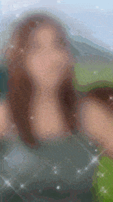 a blurry picture of a woman 's face with sparkles around her