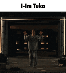a man standing in a dark room with the words i-i'm toka above him