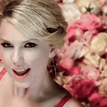 a close up of a woman 's face with a pink flower background