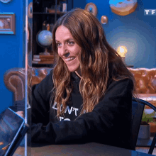 a woman wearing a black sweatshirt that says " dont " smiles