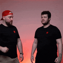 two men are standing next to each other and one has a tattoo on his hand