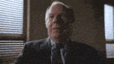 a man in a suit and tie looks up at the sky