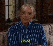 a woman wearing a blue and white striped shirt says go on