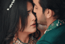 a man kissing a woman on the forehead in a close up