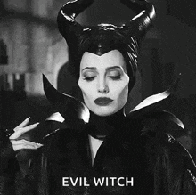 a black and white photo of a woman in a witch costume with horns .