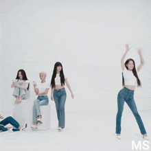 a group of women are standing in front of a white wall with the letters ms on the bottom
