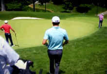a man wearing a white hat that says taylormade on it stands on a golf course
