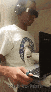 a man wearing headphones and a shirt that says " this is the future " holds a toothbrush in front of a laptop