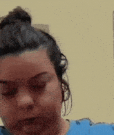 a woman in a blue shirt is making a funny face with her eyes closed .