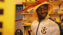a man wearing a yellow hooded jacket with the letter s on it