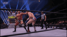 two men in a wrestling ring with aaw written on the bottom