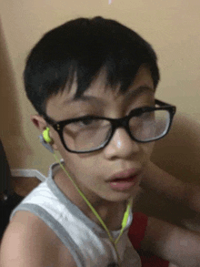 a young boy wearing glasses and ear buds