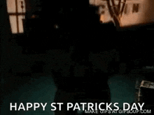 a leprechaun is dancing in a dark room with the words `` happy st patrick 's day '' written below him .