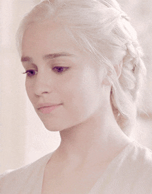 a woman with blonde hair is wearing a white top