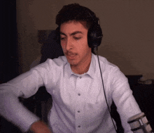 a man wearing headphones and a white shirt looks at the camera