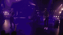 a group of people are standing on a stage with their hands in the air