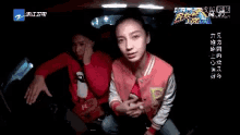 a man and a woman are sitting in the back seat of a car with chinese writing on the bottom right