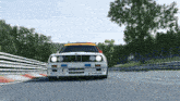 a bmw race car is driving down a race track