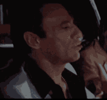 a close up of a man smoking a cigarette in a car