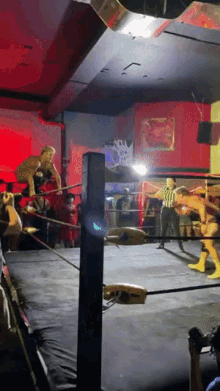 a wrestling ring with a referee and a sign on the wall that says ' wrestling '