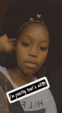 a girl is wearing a headband with butterflies on it .