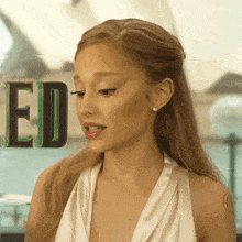 a woman in a white dress is standing in front of the word ed