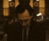 a man in a suit and tie is standing in a dark room