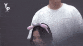 a woman wearing a headband with bunny ears is standing next to a man wearing a white t-shirt .