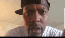 a man is wearing a hat and a white shirt .